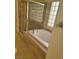 Bright bathroom featuring a soaking tub, glass block window, and tile flooring at 1540 Sabatini Dr, Henderson, NV 89052
