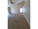Spacious bedroom with neutral carpeting, a ceiling fan, and large windows that fill the room with light at 1540 Sabatini Dr, Henderson, NV 89052