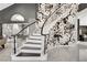 Inviting entryway with curved staircase, striking floral wallpaper, and elegant black and white accents at 165 Inveraray Ct, Henderson, NV 89074