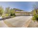 Spacious three-car garage with a wide driveway, complemented by well-maintained landscaping at 165 Inveraray Ct, Henderson, NV 89074
