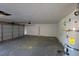 Spacious garage featuring a roll-up door and water heater at 1673 Caliente Ct, Las Vegas, NV 89119