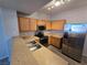 A modern kitchen with stainless steel appliances, wood cabinets, and stone countertops at 2011 Sue Ct # 203, Las Vegas, NV 89108