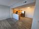 Open floor plan of the kitchen and living space with wood plank floors and stainless steel appliances at 2011 Sue Ct # 203, Las Vegas, NV 89108
