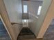 A carpeted staircase leading to an upper level with neutral walls and natural light from windows at 2011 Sue Ct # 203, Las Vegas, NV 89108