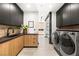 Well-equipped laundry room featuring modern washer and dryer with dark cabinets and tile backsplash at 21 Rockstream Dr, Henderson, NV 89012