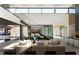 Modern living room with glass staircase and serene views of the outdoor pool and desert landscape at 21 Rockstream Dr, Henderson, NV 89012
