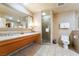 Bathroom features dual sinks, granite counters, large mirror, and glass-enclosed shower at 211 E Flamingo Rd # 1011, Las Vegas, NV 89169