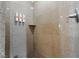 Shower stall featuring neutral stone tiled walls and mounted soap dispensers at 211 E Flamingo Rd # 1011, Las Vegas, NV 89169