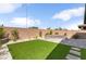 Landscaped backyard featuring artificial grass, a stone bench, and desert plants at 2114 Cold Canyon Ave, North Las Vegas, NV 89086