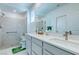 Bright bathroom featuring a double vanity, framed mirrors, and a glass-enclosed shower at 2114 Cold Canyon Ave, North Las Vegas, NV 89086
