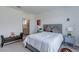 Cozy bedroom showcasing a comfortable queen bed, bench, and access to an ensuite bathroom at 2114 Cold Canyon Ave, North Las Vegas, NV 89086