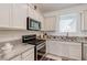 Well-lit kitchen showcasing granite countertops, stainless steel appliances, white cabinets, and a convenient layout at 2114 Cold Canyon Ave, North Las Vegas, NV 89086