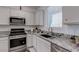 Well-equipped kitchen with stainless steel appliances, granite countertops, white cabinets, and natural light at 2114 Cold Canyon Ave, North Las Vegas, NV 89086