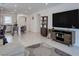Spacious living room with open layout to kitchen, featuring tile flooring, and a large-screen TV for entertainment at 2114 Cold Canyon Ave, North Las Vegas, NV 89086