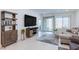 Bright living room with a large TV, comfortable seating, stylish furnishings, and sliding glass doors leading to the backyard at 2114 Cold Canyon Ave, North Las Vegas, NV 89086