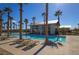Community pool area with palm trees, lounge chairs, and a modern pool house for relaxation and recreation at 2114 Cold Canyon Ave, North Las Vegas, NV 89086