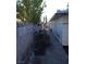 Long side yard featuring concrete path, concrete block fence, and a metal gate at 212 Bradshaw Way, Las Vegas, NV 89145