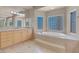 Bright bathroom featuring a large soaking tub, tile flooring, and dual vanities at 2290 Casa Bella Ct, Las Vegas, NV 89117