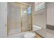 Bright bathroom featuring a shower with gold trim, a toilet, and a sink with neutral countertops at 2290 Casa Bella Ct, Las Vegas, NV 89117