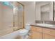 Bright bathroom featuring a shower with gold trim, a toilet, and a sink with neutral countertops at 2290 Casa Bella Ct, Las Vegas, NV 89117