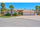 Attractive single-story home featuring a three-car garage, arched entryway, and desert landscaping at 2290 Casa Bella Ct, Las Vegas, NV 89117