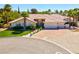 Charming single-story home features a spacious driveway, well-manicured lawn, and desert landscaping with palm trees at 2290 Casa Bella Ct, Las Vegas, NV 89117