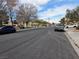 Wide street featuring lush lawns, sidewalks, and parked cars under a partly cloudy sky at 2606 Heartland Ave, Henderson, NV 89074