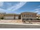Attractive single-story home with a three-car garage, desert landscaping, and a tile roof under a blue sky at 2743 Evergreen Oaks Dr, Henderson, NV 89052