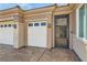 Close up of home's garages, gated entrance, and desert landscaping at 2743 Evergreen Oaks Dr, Henderson, NV 89052