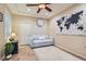 Comfortable living room featuring a neutral sofa, world map art, and a modern ceiling fan at 2743 Evergreen Oaks Dr, Henderson, NV 89052