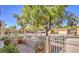 Charming street view showcasing a well-maintained property with mature trees and a wrought iron gate at 2824 Dry Plains Dr, Las Vegas, NV 89134