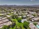 Expansive aerial view of a community with single-Gathering homes, lush trees, and mountains in distance at 3 Glendora Ct, Henderson, NV 89052