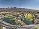 Aerial shot of a golf course community with a scenic lake and mountain backdrop at 3 Glendora Ct, Henderson, NV 89052
