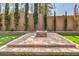 Landscaped backyard featuring a fire pit, stone retaining walls, and artificial turf at 3 Glendora Ct, Henderson, NV 89052
