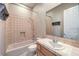 Full bathroom with neutral-toned tile, a single vanity, and a shower-tub combo at 3 Glendora Ct, Henderson, NV 89052