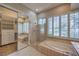 Bright bathroom featuring a large soaking tub, glass enclosed shower, and custom plantation shutters at 3 Glendora Ct, Henderson, NV 89052