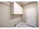 Laundry room featuring clean white cabinets and tile flooring, and access to the garage at 3 Glendora Ct, Henderson, NV 89052