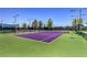 Brightly lit community tennis court with well-maintained surface and net, ready for a match at 3 Glendora Ct, Henderson, NV 89052