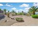 Lush backyard oasis with mature palm trees, desert landscaping, stone benches and walkways for relaxing and entertaining at 3051 Scotts Valley Dr, Henderson, NV 89052
