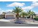 Charming home featuring desert landscaping, a two-car garage and several mature palm trees at 3051 Scotts Valley Dr, Henderson, NV 89052