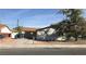 A single-story home with a driveway, carport, desert landscaping, and chain-link fence at 3258 Glenhurst Dr, Las Vegas, NV 89121
