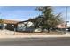 Street view of a single-story home with a large tree in the front yard and a chain-link fence at 3258 Glenhurst Dr, Las Vegas, NV 89121