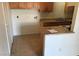 Kitchen with linoleum floors, simple wooden cabinets, basic appliances, and a separate laundry area at 3258 Glenhurst Dr, Las Vegas, NV 89121