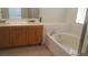 Bathroom vanity featuring double sinks and a soaking tub at 33 Newburg Ave, North Las Vegas, NV 89032