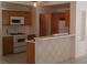Kitchen featuring wood cabinets, white appliances, and a breakfast bar is ready for cooking at 33 Newburg Ave, North Las Vegas, NV 89032