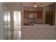Galley kitchen showcasing wood cabinets, white appliances, and a breakfast bar for casual dining at 33 Newburg Ave, North Las Vegas, NV 89032