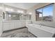 Bathroom with a free-standing tub, dual vanities, and a large window at 342 Molinetto St, Las Vegas, NV 89138
