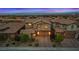 Charming two-story home in a desert setting, beautifully lit with a well manicured front lawn and landscape at 342 Molinetto St, Las Vegas, NV 89138