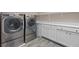 Laundry room with modern washer, dryer, storage cabinets, and shelving at 342 Molinetto St, Las Vegas, NV 89138