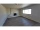 Living room showcasing wood-look floors, a bright window, and a painted brick fireplace at 3749 Ponderosa Ave, Las Vegas, NV 89115